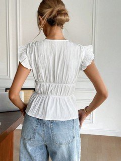 Back view of the white and black bow-front flutter-sleeve blouse, showing its silhouette and design details.