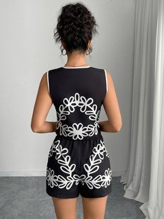 Back view of the black and white embroidered vest and shorts set, showing its silhouette and design details.