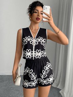 Styled front view of the black and white embroidered vest and shorts set, showing its silhouette and design details.
