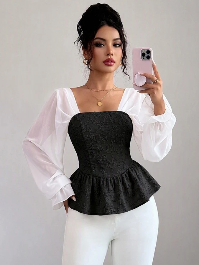 Angled front view of the black contrast mesh puff-sleeve corset peplum top, showing the silhouette and fit.
