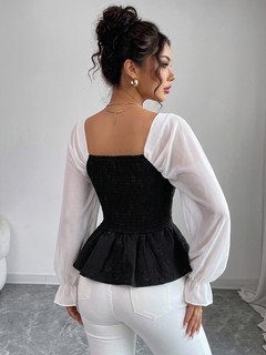 Back view of the black contrast mesh puff-sleeve corset peplum top, showing the silhouette and fit.