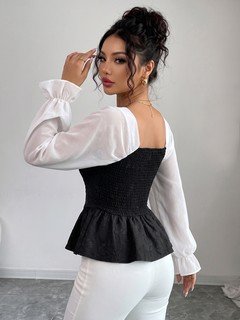 Side view of the black contrast mesh puff-sleeve corset peplum top, showing the silhouette and fit.