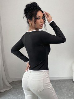 Side view of the black contrast-piping tie-front long-sleeve top, showing the silhouette and fit.