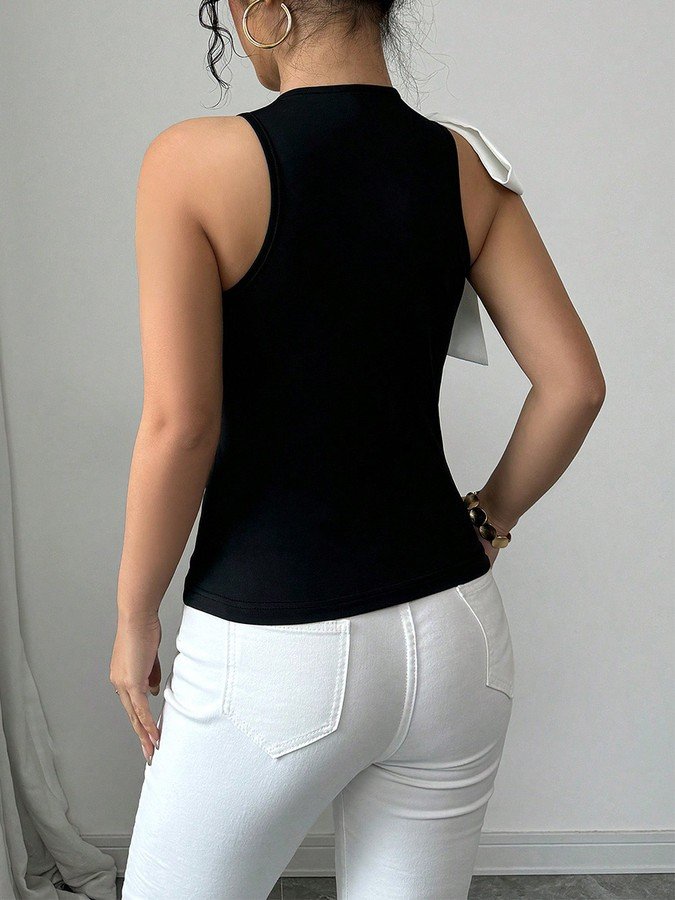 Back view of the black and white shoulder-bow sleeveless top, showing its silhouette and design details.