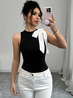 Angled front view of the black and white shoulder-bow sleeveless top, showing its silhouette and design details.