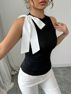 Close-up of the black and white shoulder-bow sleeveless top, showing its silhouette and design details.