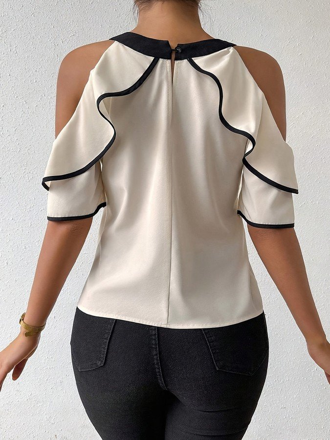 Back view of the ivory and black bow-neck cold-shoulder blouse, showing its silhouette and design details.