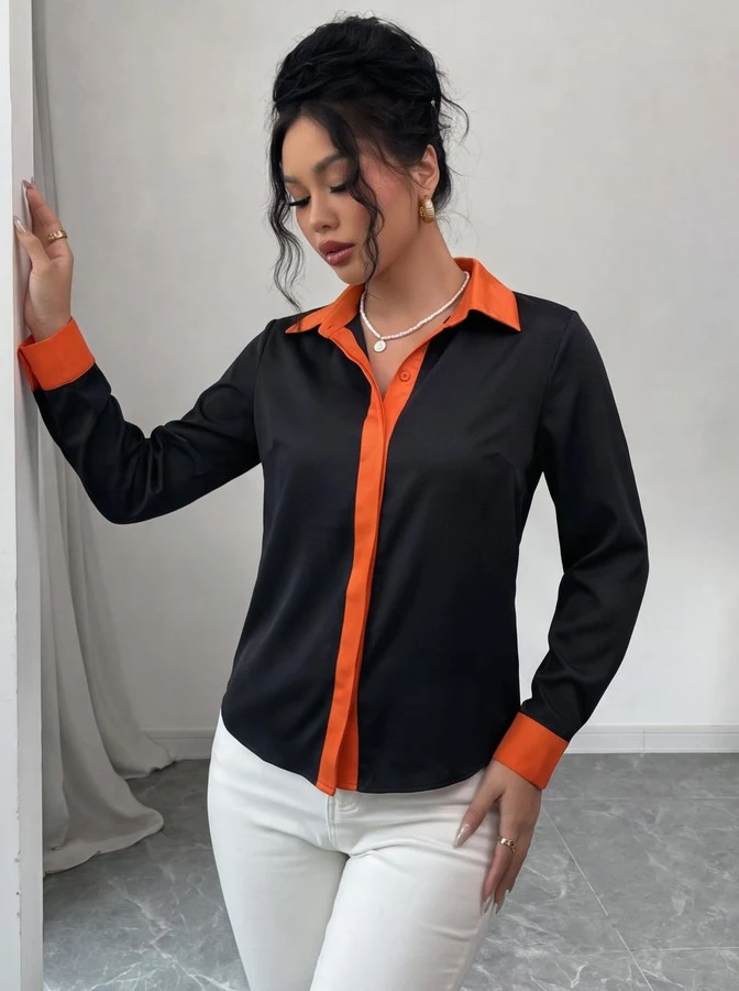 Angled front view of the black contrast-trim long-sleeve button-up shirt, showing the silhouette and fit.