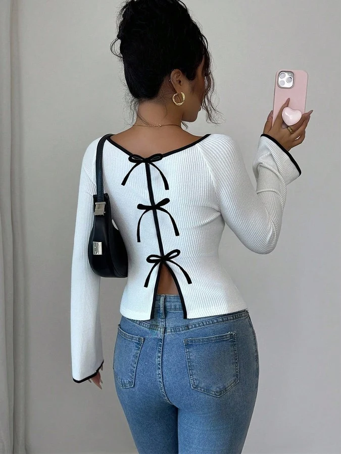 Back view of the white and black bow-back contrast-trim ribbed top, showing its silhouette and design details.
