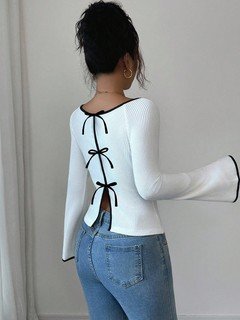 Angled back view of the white and black bow-back contrast-trim ribbed top, showing its silhouette and design details.
