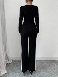 Back view of the black contrast-trim square-neck long-sleeve jumpsuit, showing the silhouette and fit.