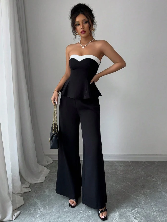 Angled front view of the black contrast-trim strapless peplum top and wide-leg pants set, showing the silhouette and fit.