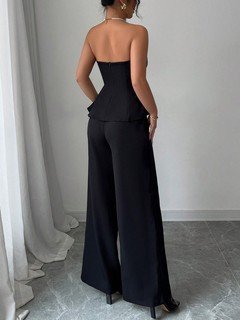 Back view of the black contrast-trim strapless peplum top and wide-leg pants set, showing the silhouette and fit.