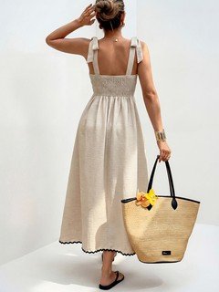 Full back view of the cream and black contrast-trim tie-strap maxi dress, showing its silhouette and design details.