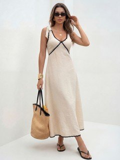 Studio front view of the cream and black contrast-trim tie-strap maxi dress, showing its silhouette and design details.