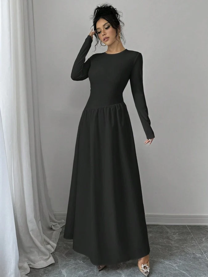 Angled front view of the black long-sleeve fit-and-flare maxi dress, showing its silhouette and design details.