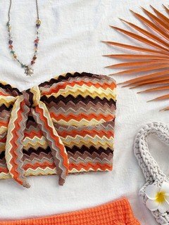 Set flat lay of the orange crochet bandeau top and high-waist shorts set, showing the garment shape and available styling.