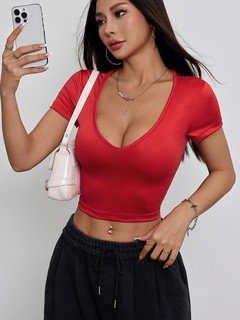 Lifestyle front view of the red deep scoop-neck fitted crop top, showing its silhouette and design details.
