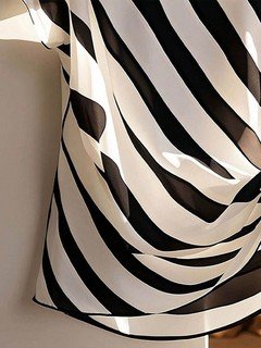 Construction detail of the black and cream diagonal stripe side-tie blouse, showing the garment finish.
