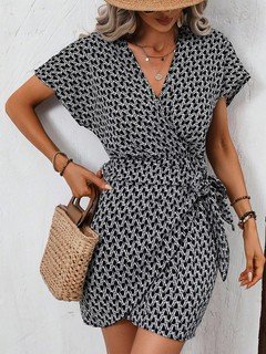 Styled front view of the black and white ditsy print tie-waist wrap dress, showing its silhouette and design details.