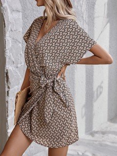 Angled front view of the brown ditsy print tie-waist wrap dress, showing its silhouette and design details.