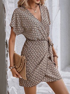 Full-length front view of the brown ditsy print tie-waist wrap dress, showing its silhouette and design details.