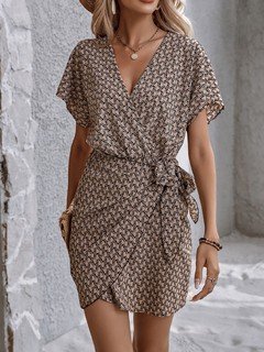 Styled front view of the brown ditsy print tie-waist wrap dress, showing its silhouette and design details.