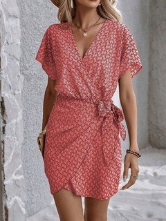 Angled front view of the coral ditsy print tie-waist wrap dress, showing its silhouette and design details.