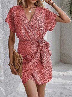 Front view of the coral ditsy print tie-waist wrap dress, showing its silhouette and design details.