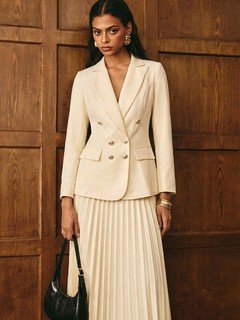 Lifestyle front view of the cream blazer and pleated midi skirt set, showing its silhouette and design details.