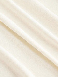 Fabric detail of the ivory draped ruched asymmetric flared-sleeve top, showing asymmetric hem, side ruching and flared cuffs.