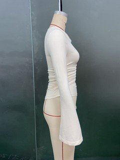 Mannequin side view of the ivory draped ruched asymmetric flared-sleeve top, showing the silhouette and fit.