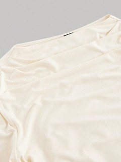 Ruched detail of the ivory draped ruched asymmetric flared-sleeve top, showing asymmetric hem, side ruching and flared cuffs.