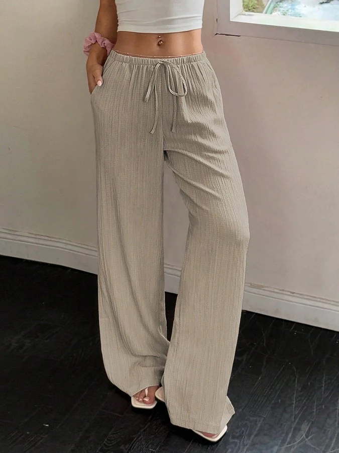 Front view of the beige drawstring wide-leg pants, showing its silhouette and design details.