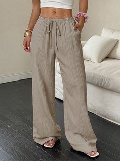 Full-length front view of the beige drawstring wide-leg pants, showing its silhouette and design details.
