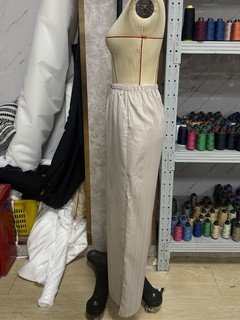Mannequin view of the beige drawstring wide-leg pants, showing the garment shape and construction.