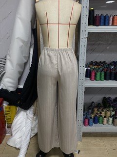Mannequin view of the beige drawstring wide-leg pants, showing the garment shape and construction.