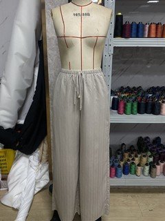 Mannequin view of the beige drawstring wide-leg pants, showing the garment shape and construction.
