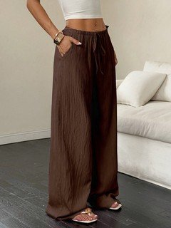 Lifestyle front view of the brown drawstring wide-leg pants, showing its silhouette and design details.