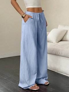 Angled front view of the light blue drawstring wide-leg pants, showing its silhouette and design details.