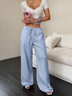 Full-length front view of the light blue drawstring wide-leg pants, showing its silhouette and design details.