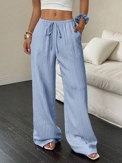Lifestyle front view of the light blue drawstring wide-leg pants, showing its silhouette and design details.
