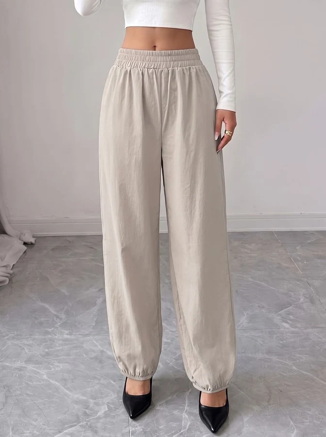 Front view of the beige drawstring-waist tapered jogger pants, showing the silhouette and fit.