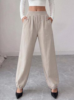 Angled front view of the beige drawstring-waist tapered jogger pants, showing the silhouette and fit.