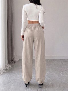Back view of the beige drawstring-waist tapered jogger pants, showing the silhouette and fit.
