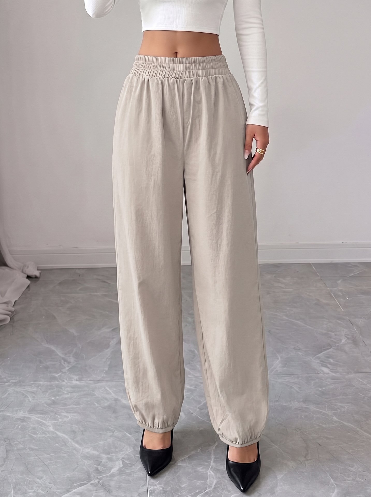 Beige Drawstring-Waist Tapered Jogger Pants – Front View Front view of the beige drawstring-waist tapered jogger pants, showing the silhouette and fit.