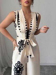 Waist detail of the ivory embroidered deep-v belted wide-leg jumpsuit, showing contrast embroidery, deep v-neck and sash waist.