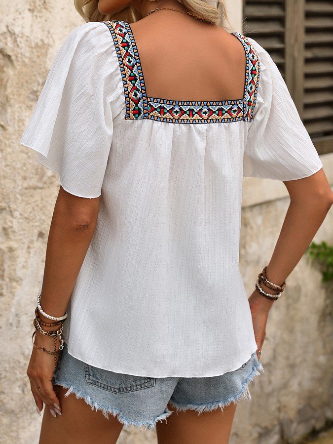 Back view of the white embroidered square-neck blouse, showing its silhouette and design details.