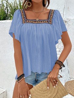 Angled front view of the blue embroidered square-neck blouse, showing its silhouette and design details.