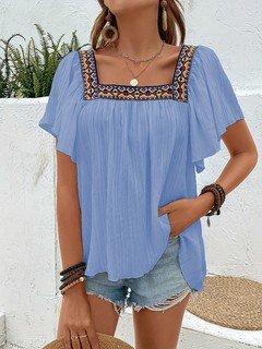 Styled front view of the blue embroidered square-neck blouse, showing its silhouette and design details.